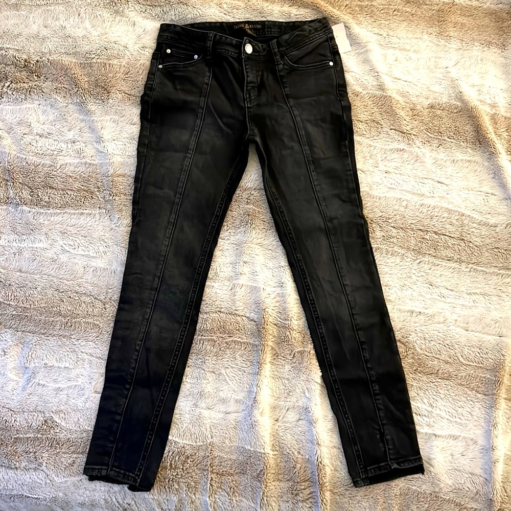 Black jeans with tailor stitch down the thigh line.